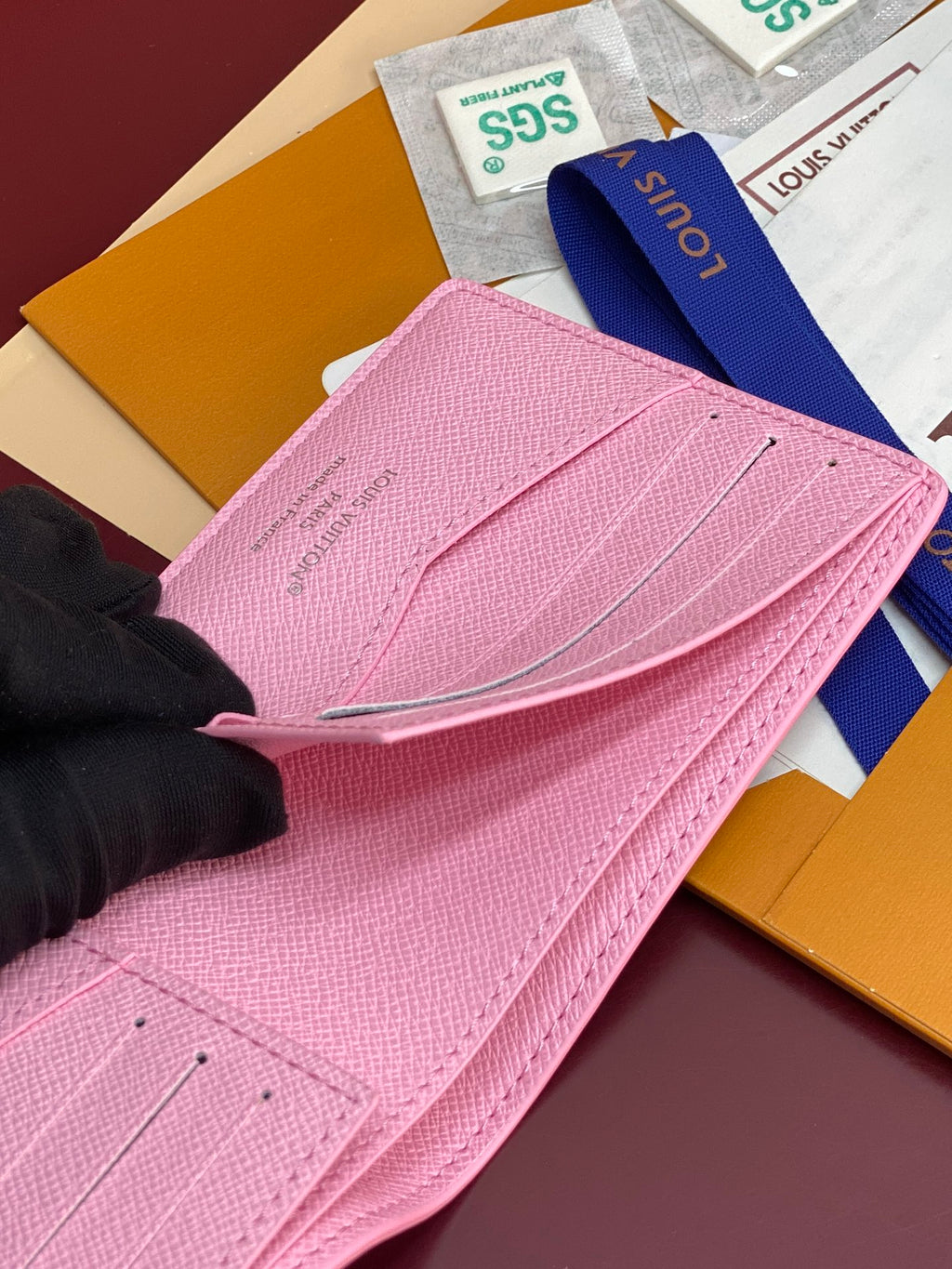 Pink small bag with flap open, showing textured leather and Louis Vuitton logo