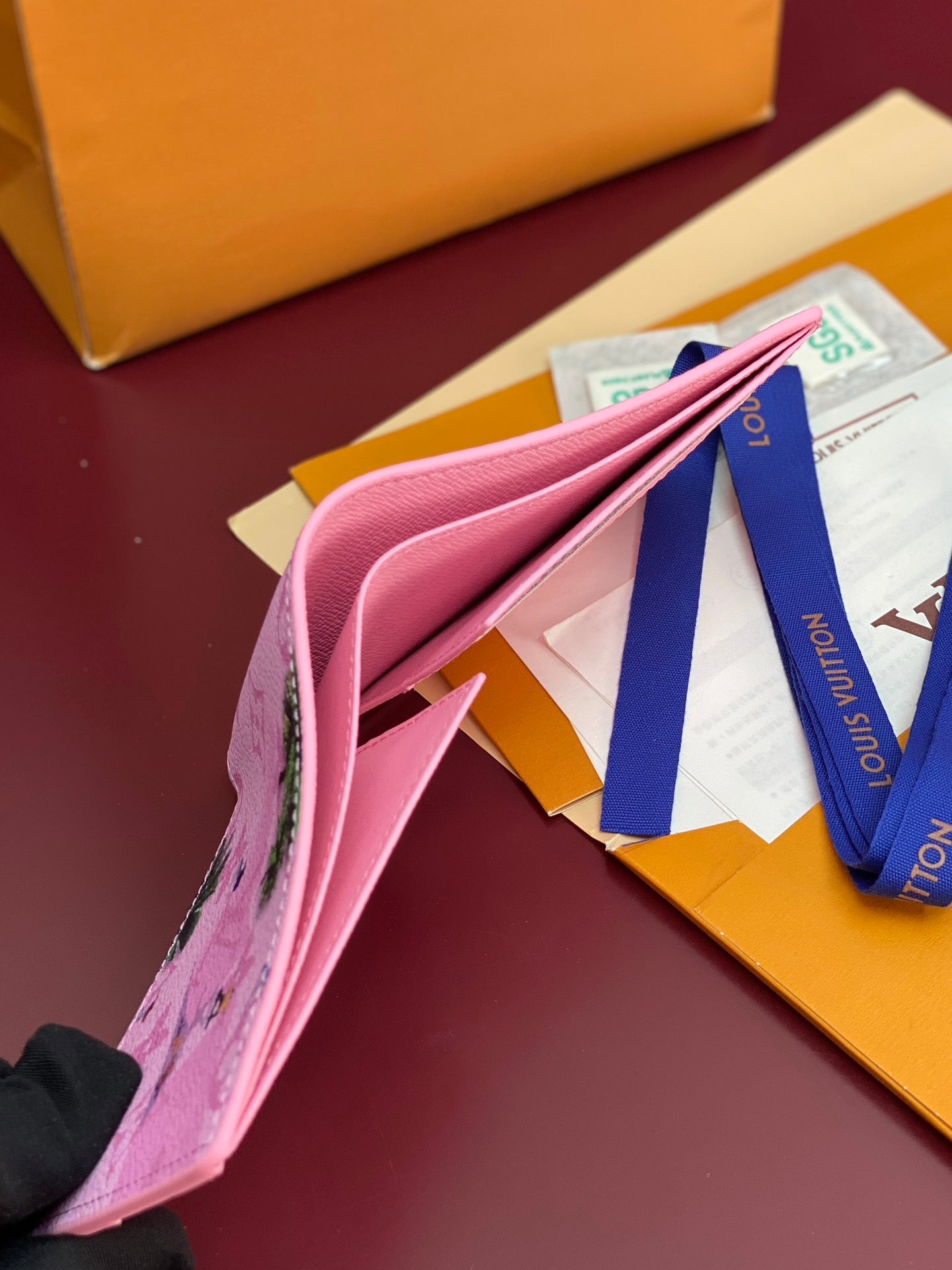 Pink small bag strap and flap edge; opened with blue tag and papers