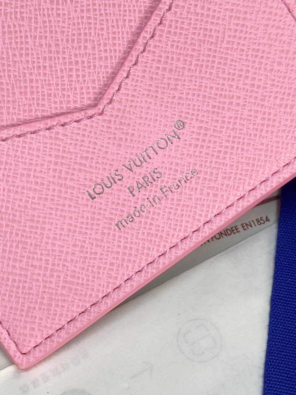 Louis Vuitton pink small bag close-up of embossed 'Louis Vuitton Paris' text