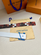 Louis Vuitton belt with checkered strap and blue LV buckle, plus beige dust bag