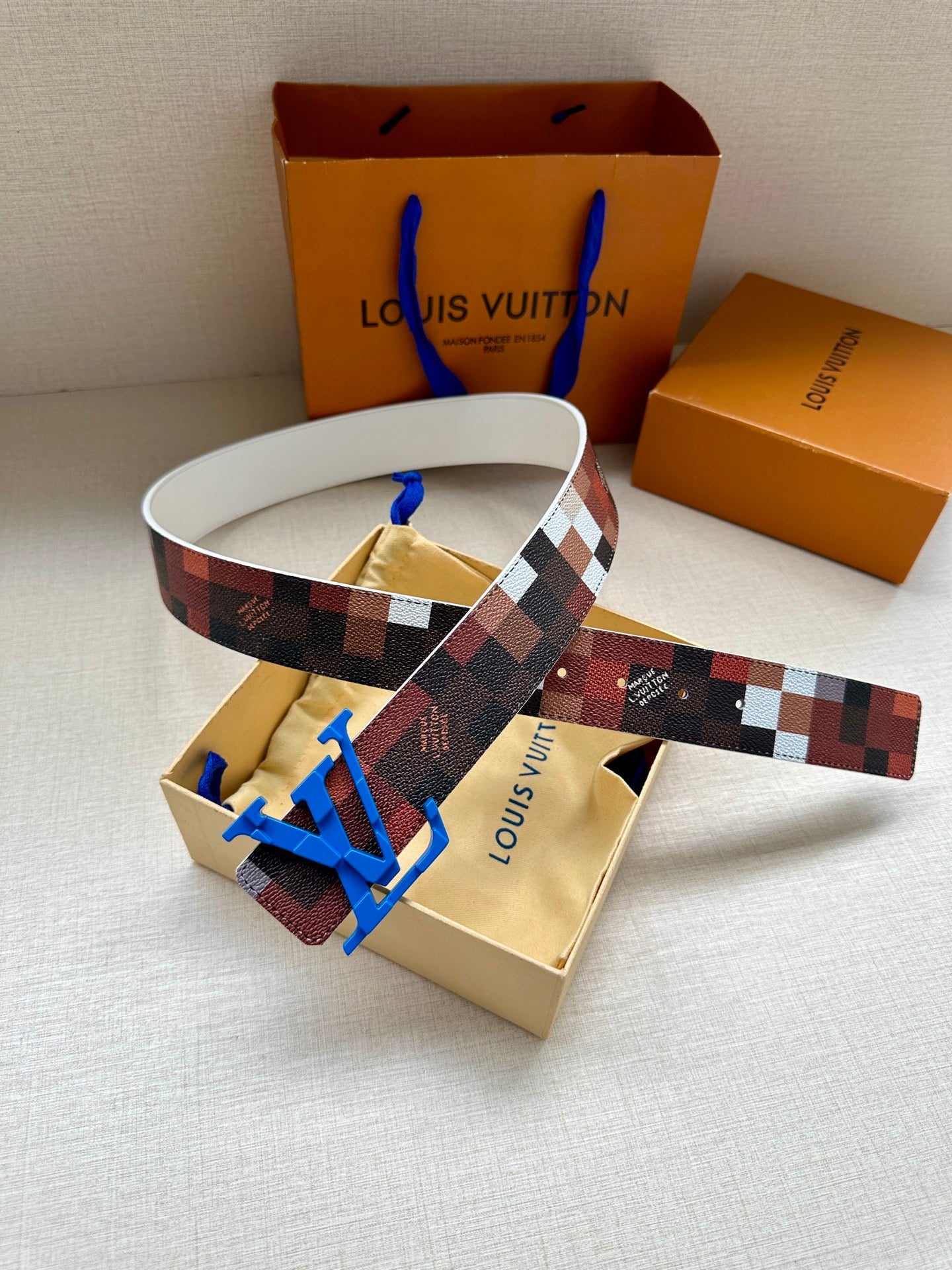 Louis Vuitton belt with checkered strap and blue LV buckle, white-edged band