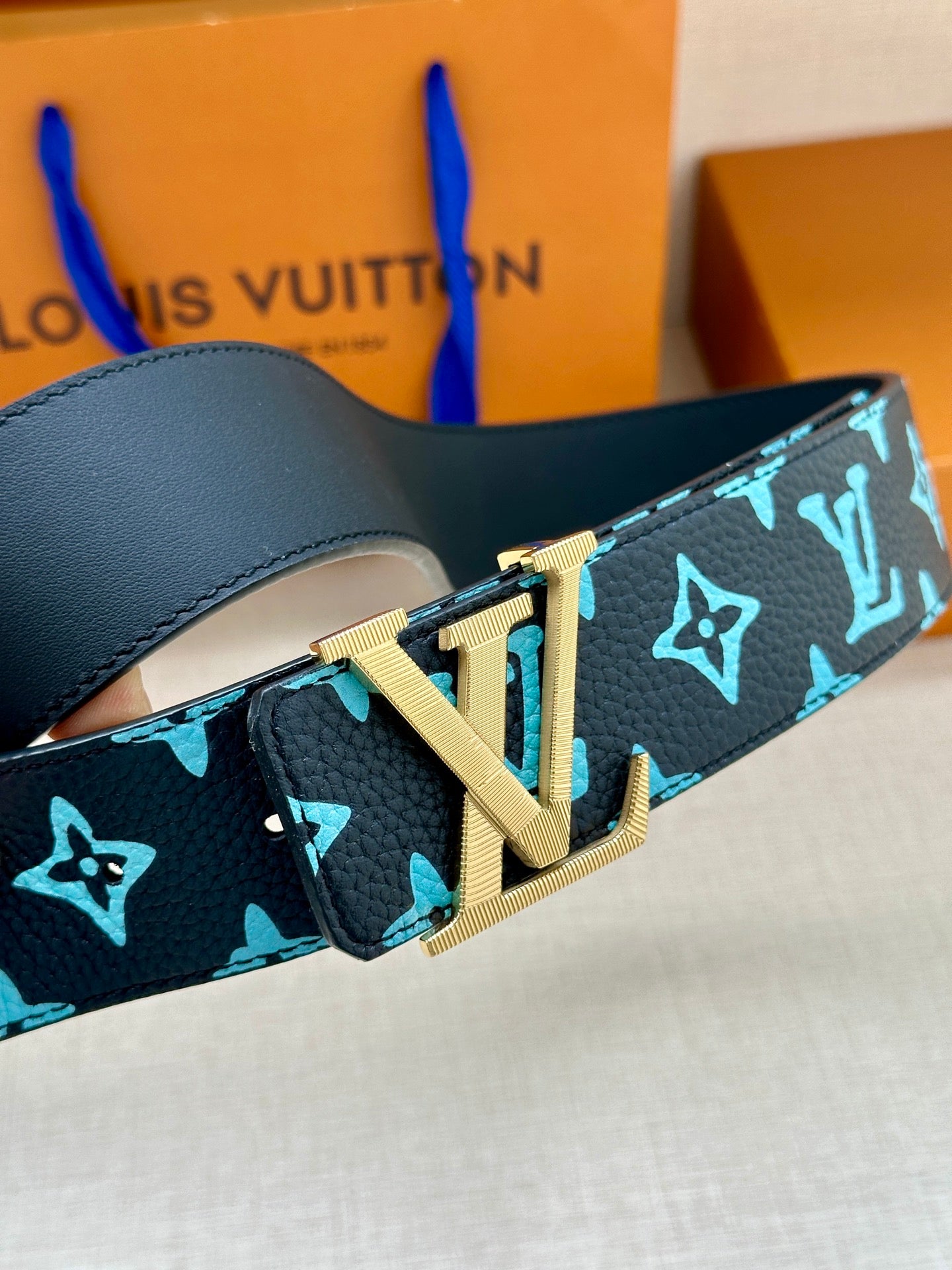 Louis Vuitton belt buckle detail on dark navy strap with turquoise monogram pattern