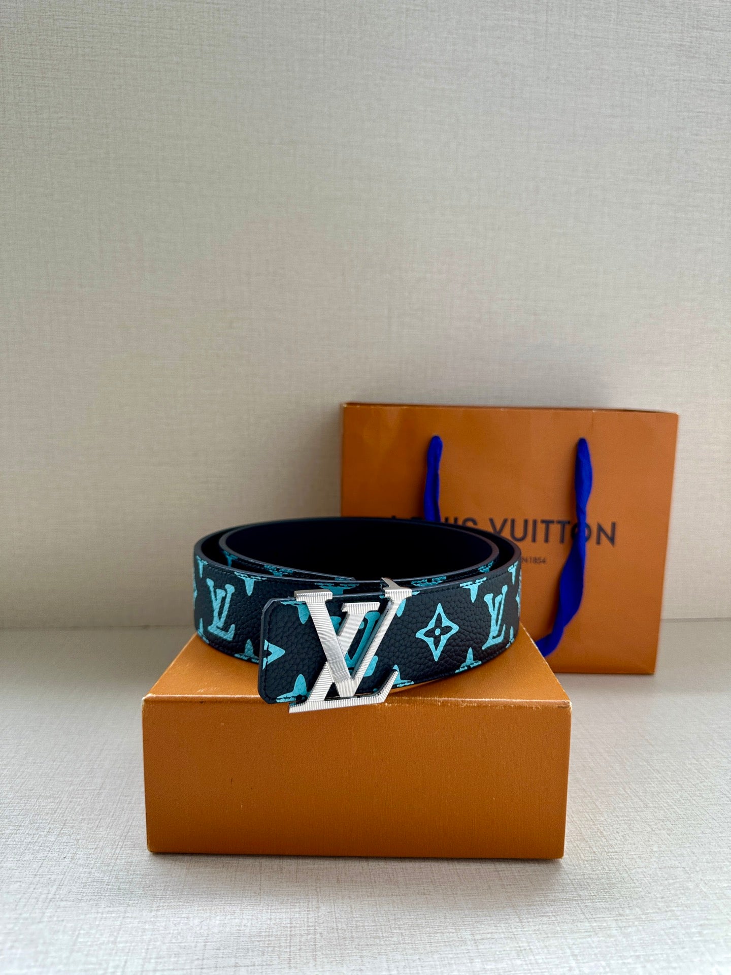 Louis Vuitton belt with navy strap and turquoise monogram pattern, centered oversized buckle
