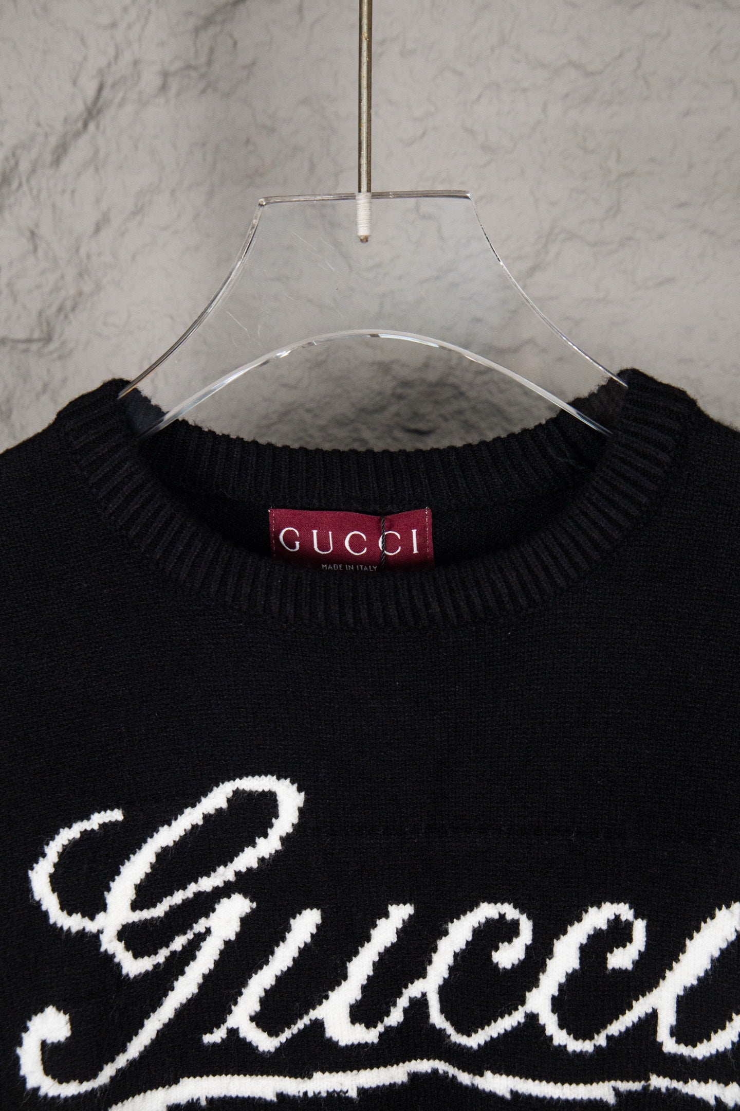 Black knit sweater neckline with Gucci logo label