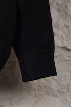 Black knit sweater hem and sleeve end with ribbed cuff
