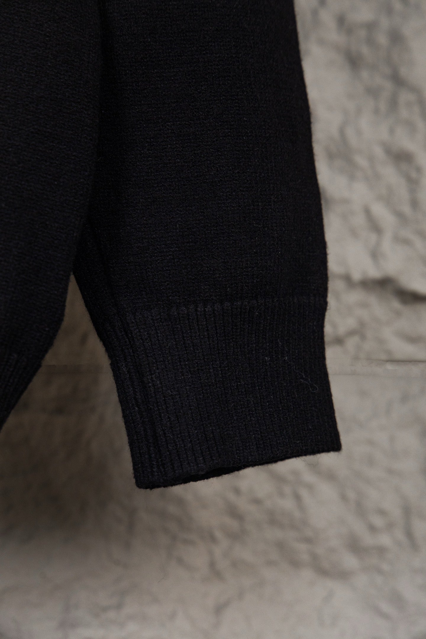 Black knit sweater hem and sleeve end with ribbed cuff