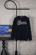 Black long-sleeve sweater on hanger with white Gucci script logo
