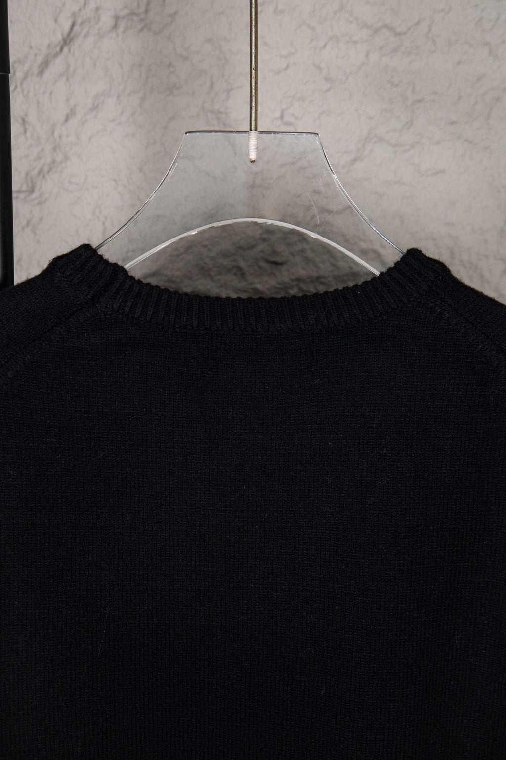Black sweater neckline with ribbed collar on hanger