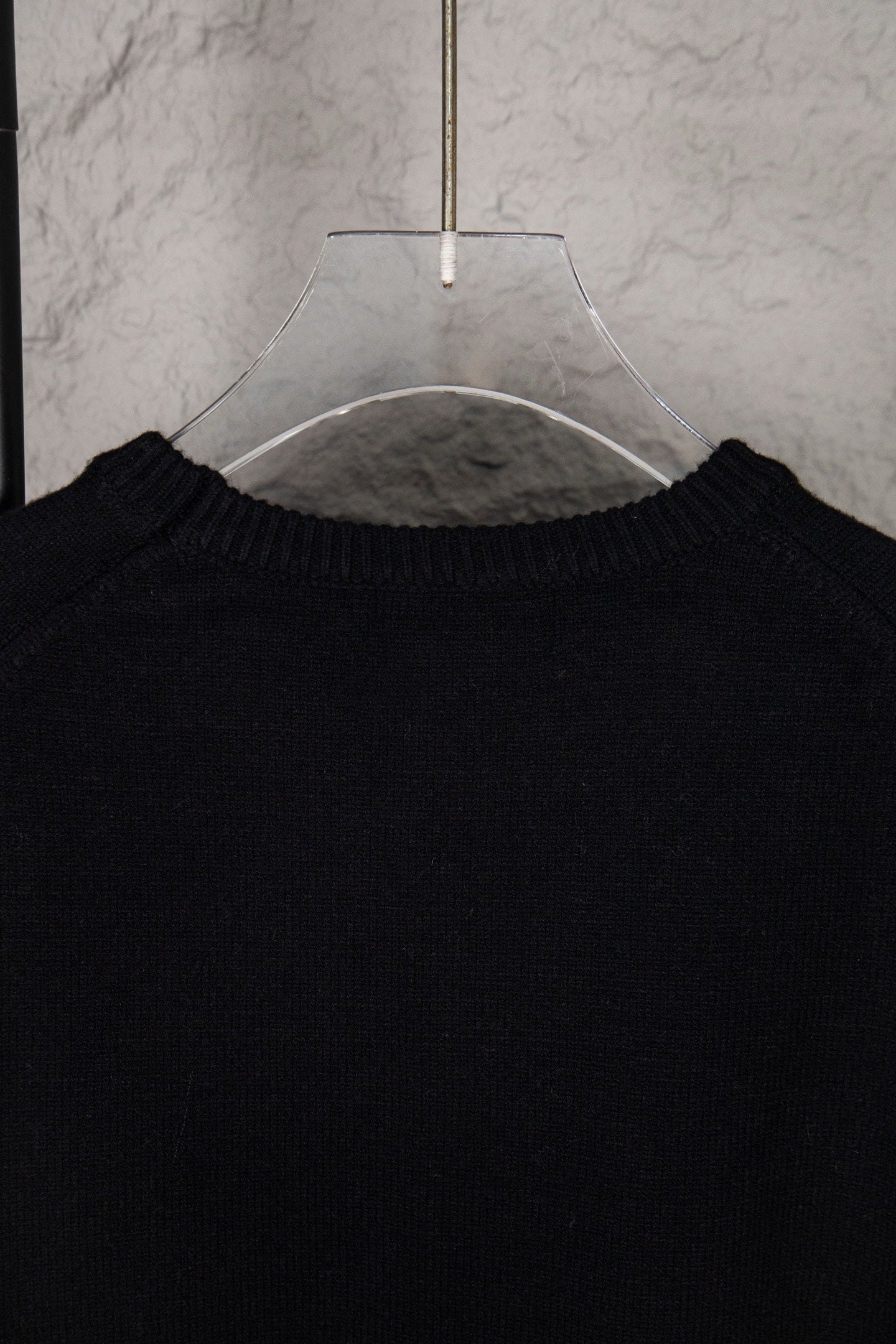 Black sweater neckline with ribbed collar on hanger