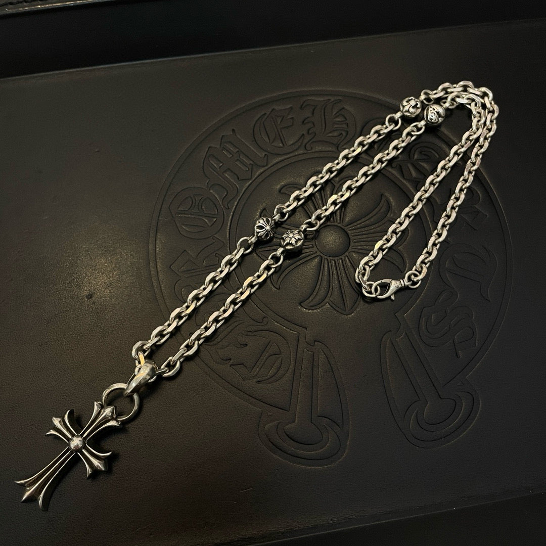 Silver cross pendant necklace with curb chain on embossed black box