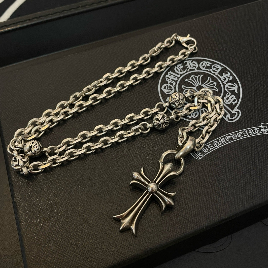 Silver cross pendant necklace with curb chain on black gift box