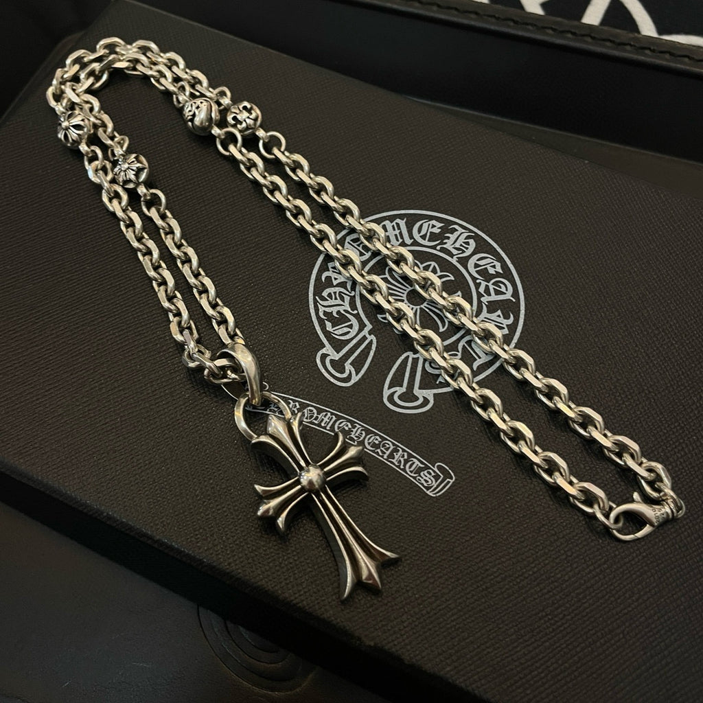 Silver cross pendant necklace with curb chain on black gift box