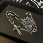 Silver-tone cross pendant necklace on leather tray with embossed emblem
