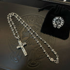 Silver-tone cross pendant bead necklace on embossed leather tray with pouch