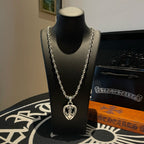 Heart pendant chain necklace with silver-tone links on black display bust