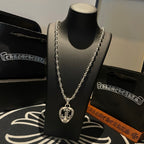 Heart pendant necklace on stand; silver-tone chain with detailed heart charm