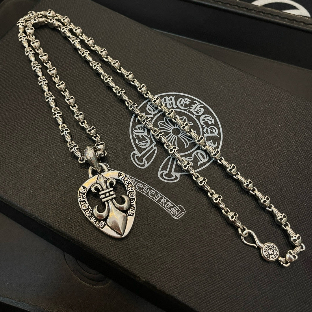 Heart pendant necklace with silver-tone chain on black accessory box