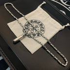 Silver-toned charm necklace with cylinder pendant on a folded cloth and box