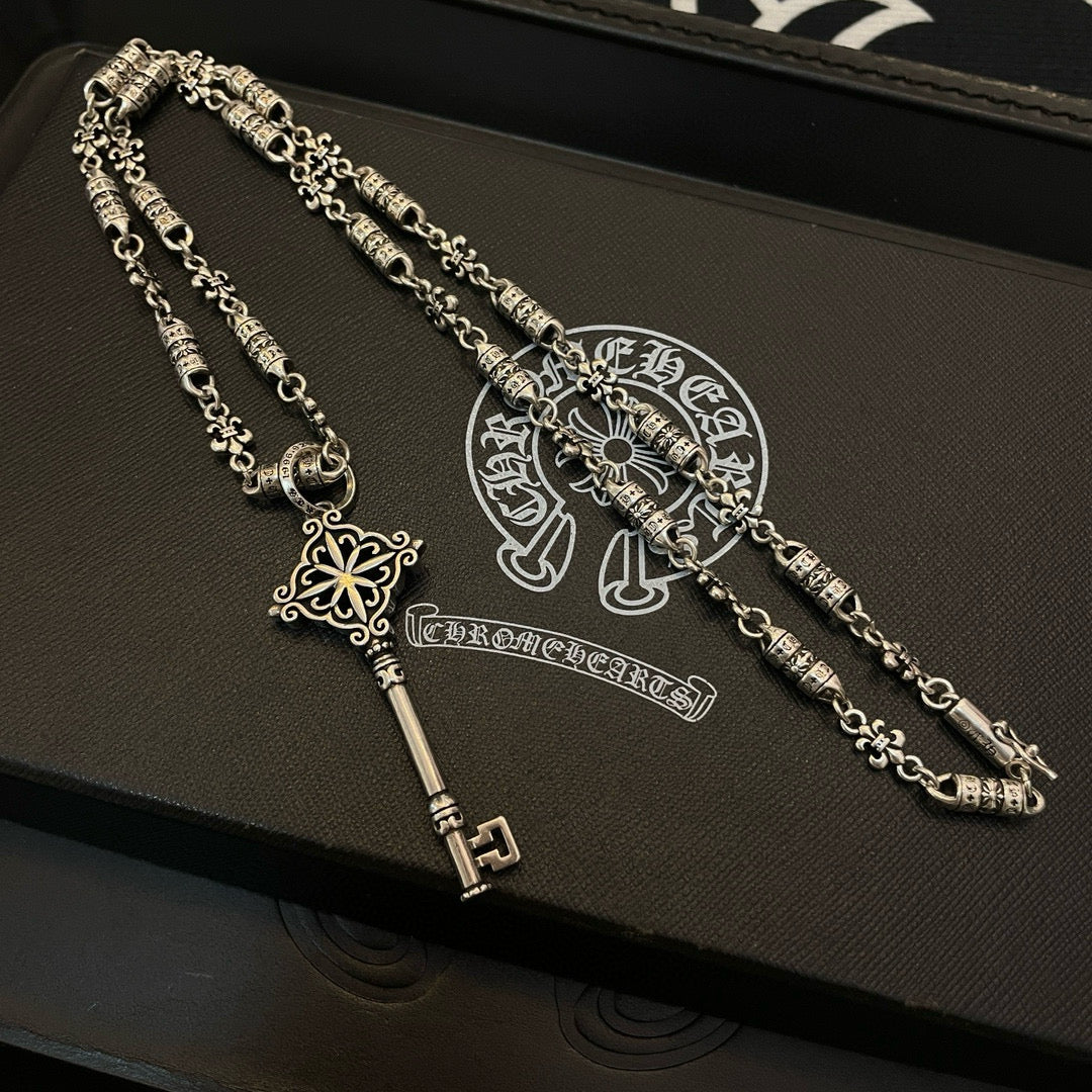 Set of two key pendant necklaces with chain, fleur charms, and key-shaped clasp