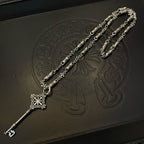 Silver-tone key pendant necklace with chain, fleur charm, and engraved bead details