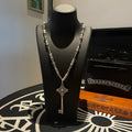 Key pendant necklace with chain and cross-style centerpiece, displayed on black bust form