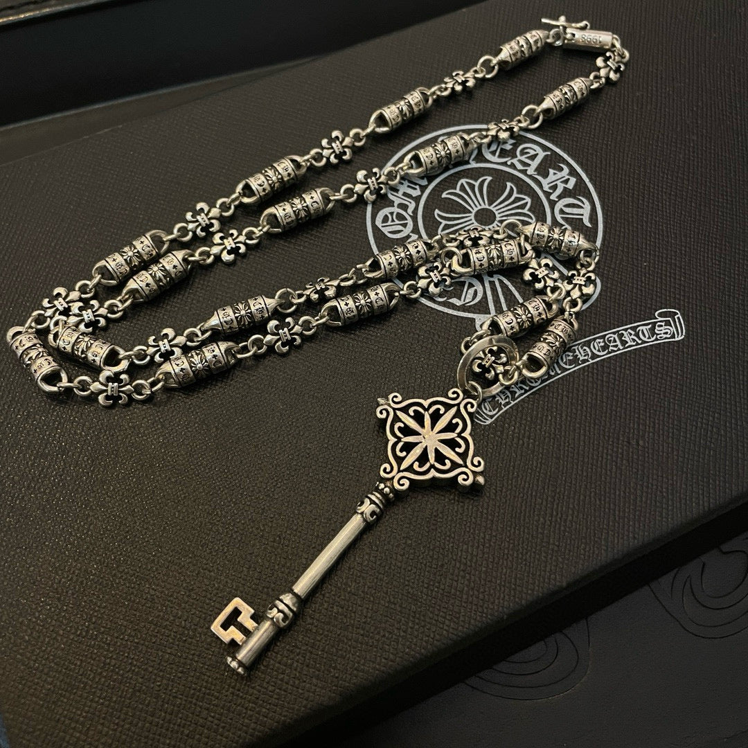 Pair of silver-tone key pendant necklaces with engraved bead chain and fleur charm