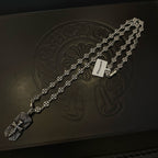 Silver beaded chain necklace laid on dark box with engraved emblem