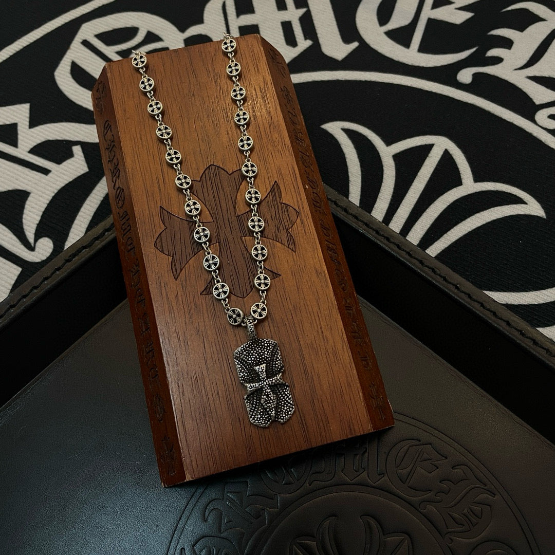 Silver beaded chain necklace with pendant charm on wooden display stand