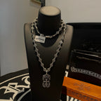 Silver beaded chain necklace with two pendants on black display bust