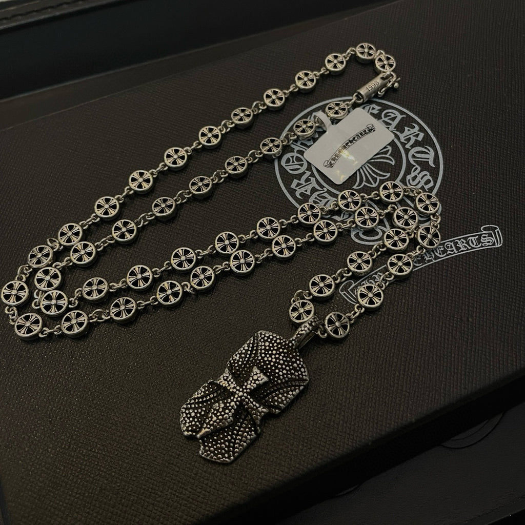 Silver beaded chain necklace with two pendant charms on dark case