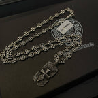 Silver beaded chain necklace with two pendant charms on dark case