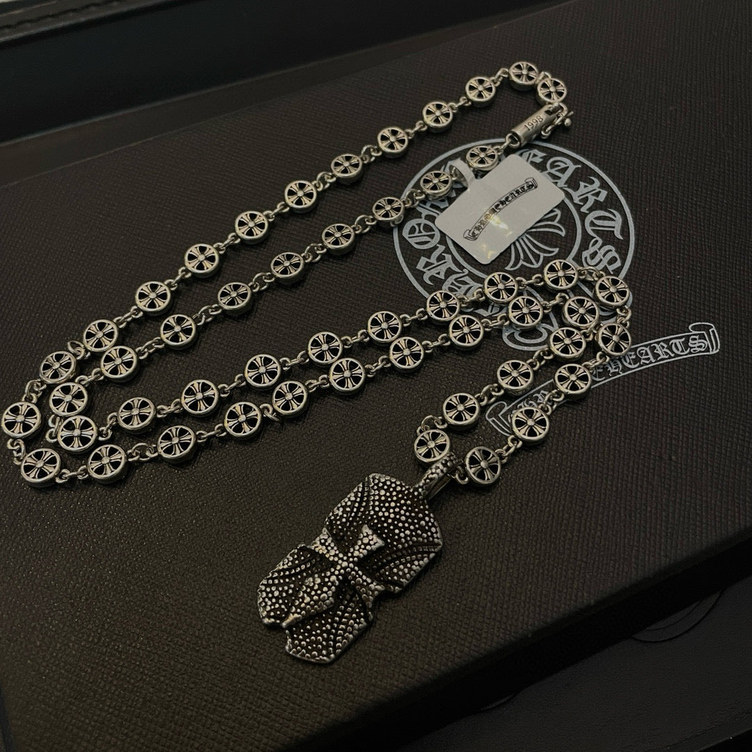 Silver beaded chain necklace with two pendant charms on dark case