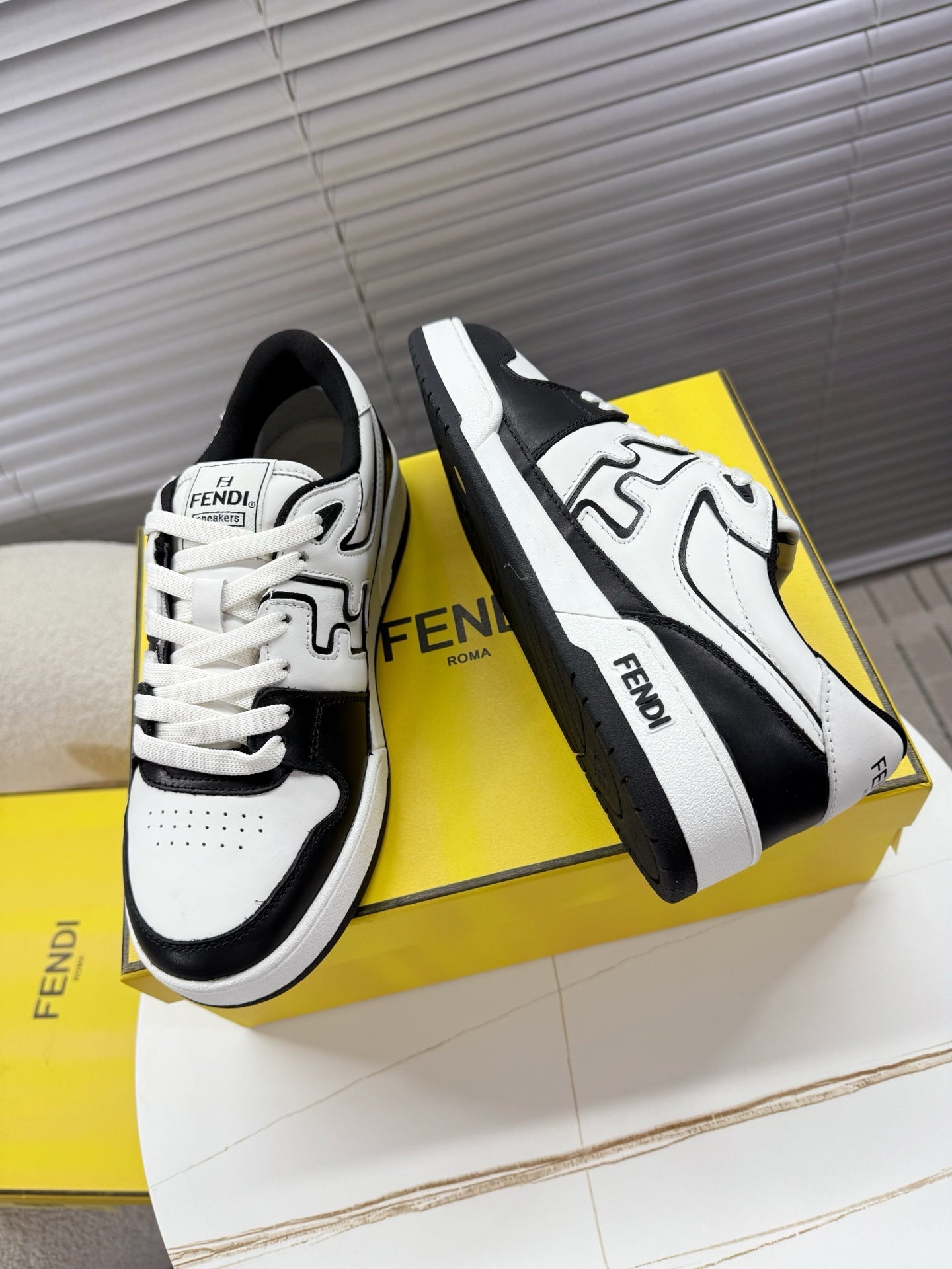 White and black lace-up low-top sneakers with FENDI logo strap detail on side