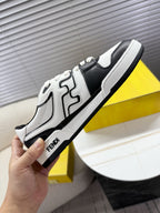 White and black lace-up low-top sneakers held in hand, side logo detail