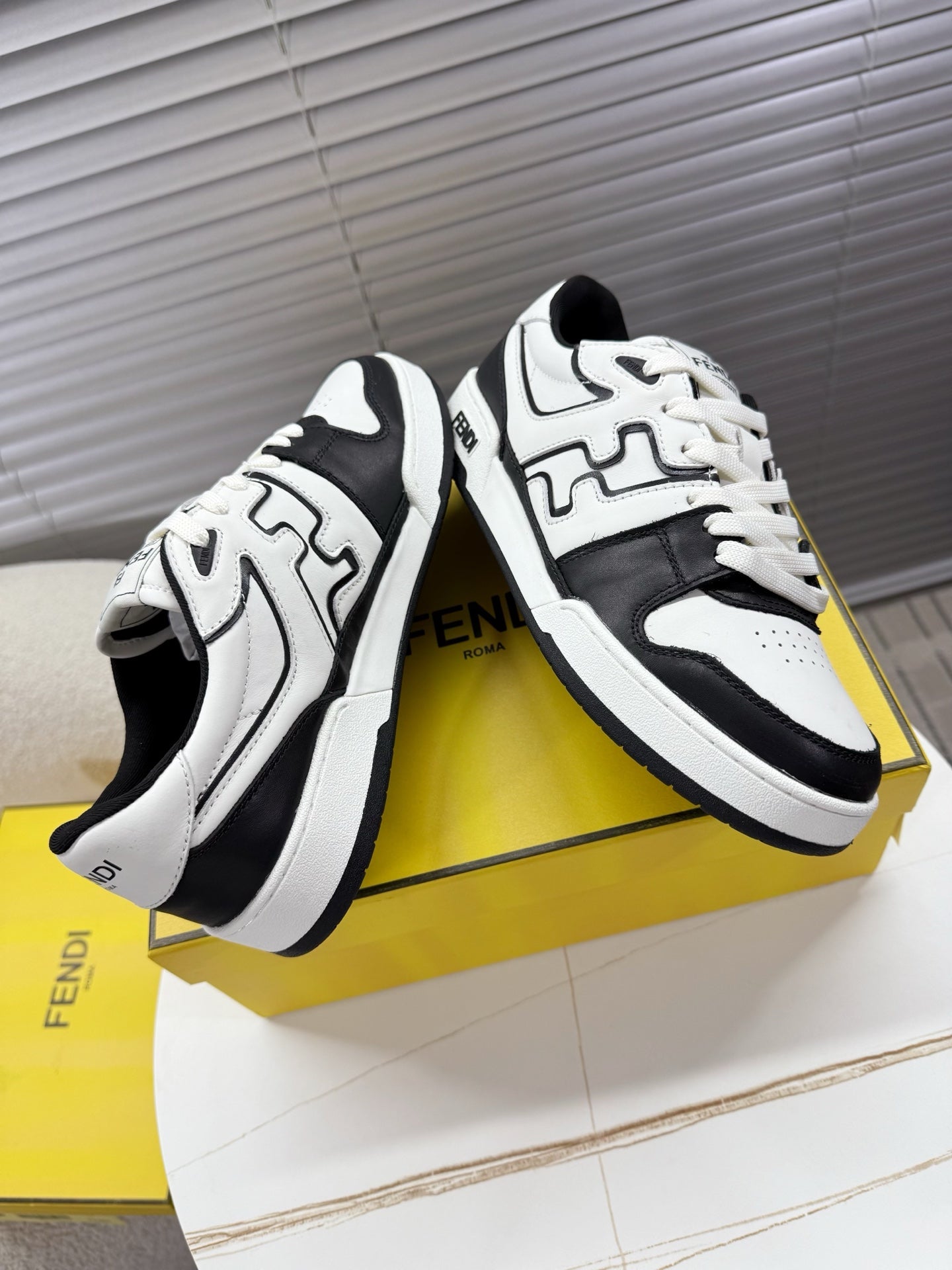 White and black lace-up low-top sneakers with FENDI logo, side and toe view