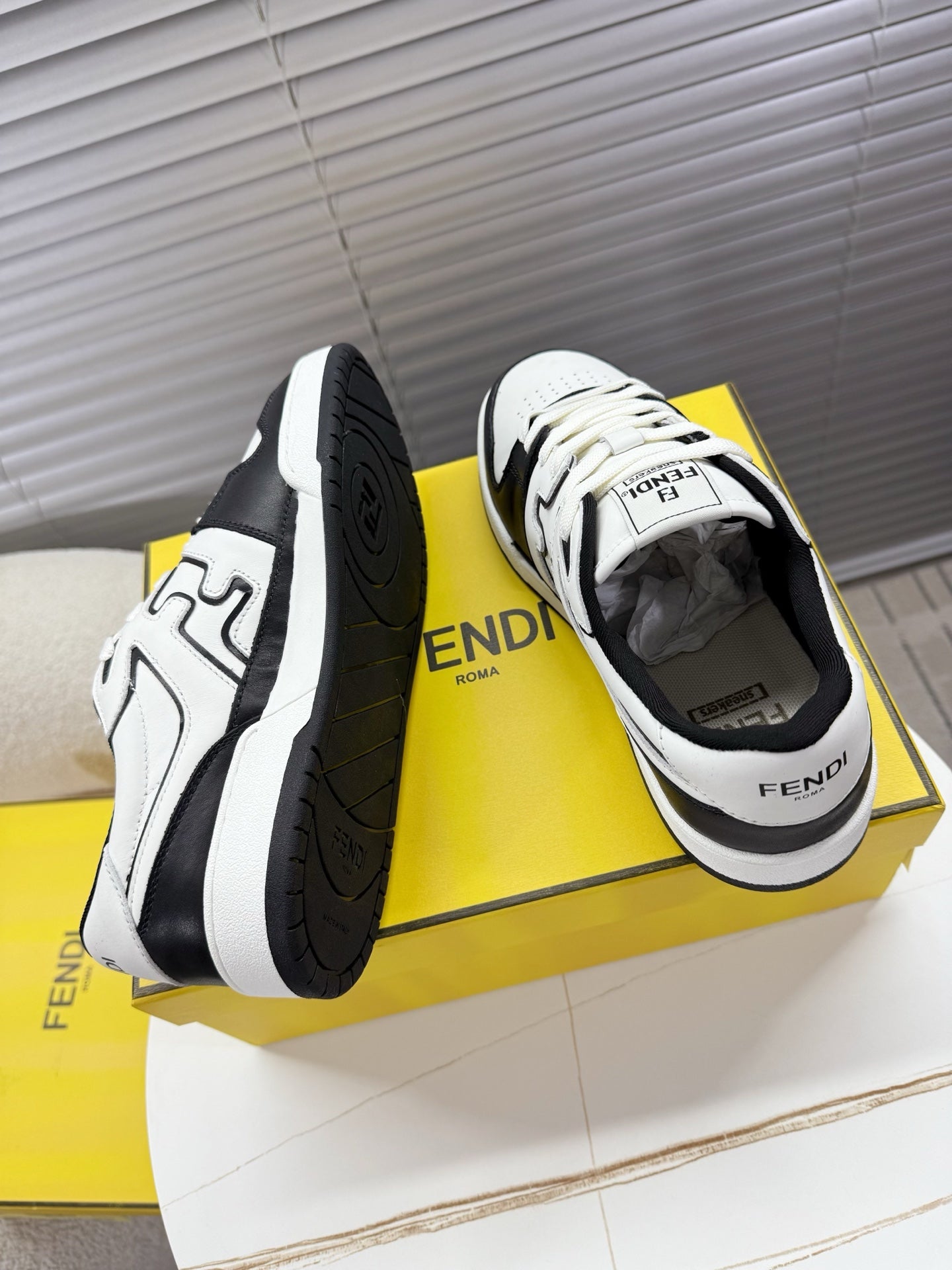 White and black FENDI low-top sneakers shown from back with lace-up front