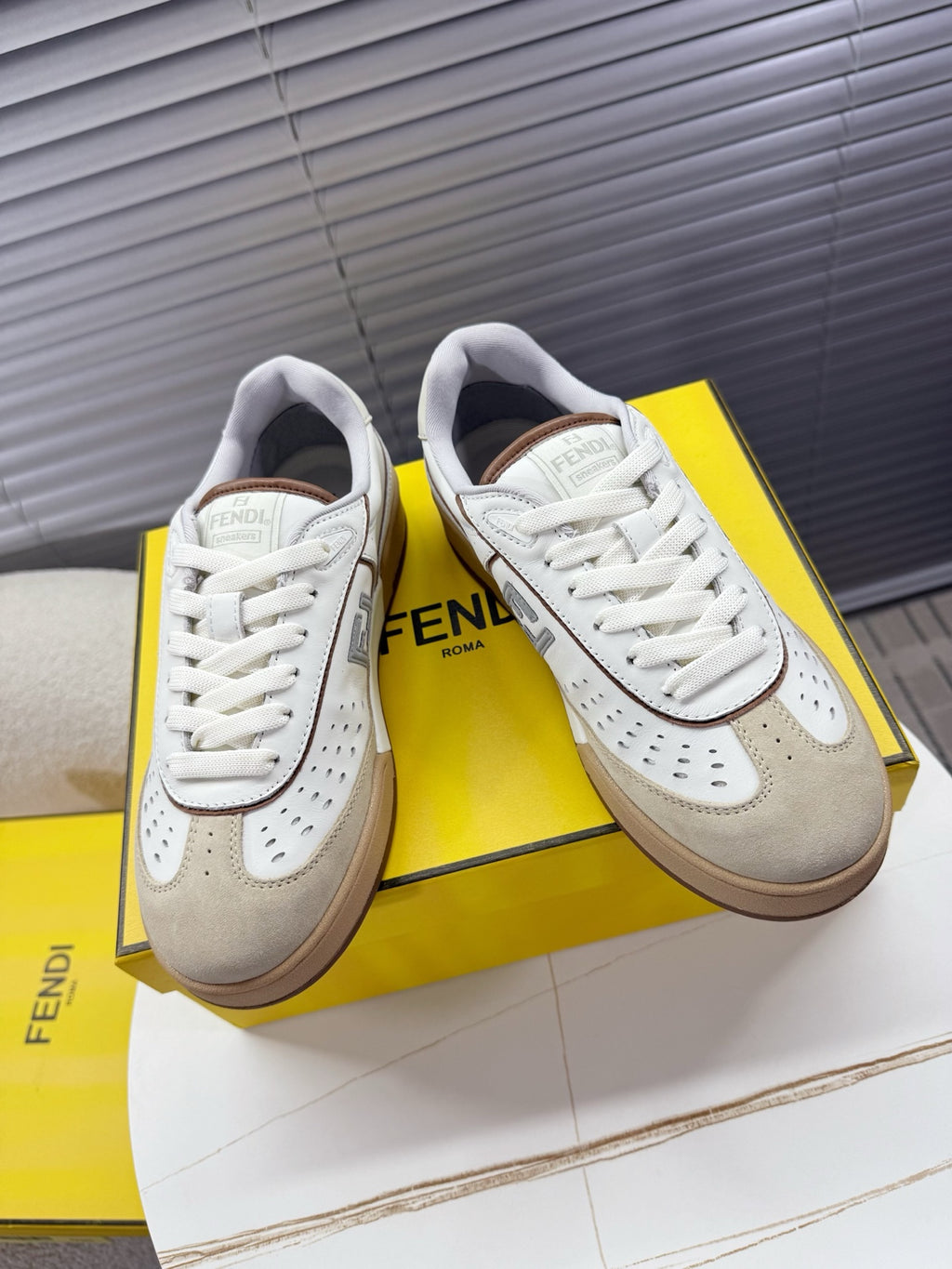 Fendi unisex sneakers in white with beige accents, lace-up with perforated details.