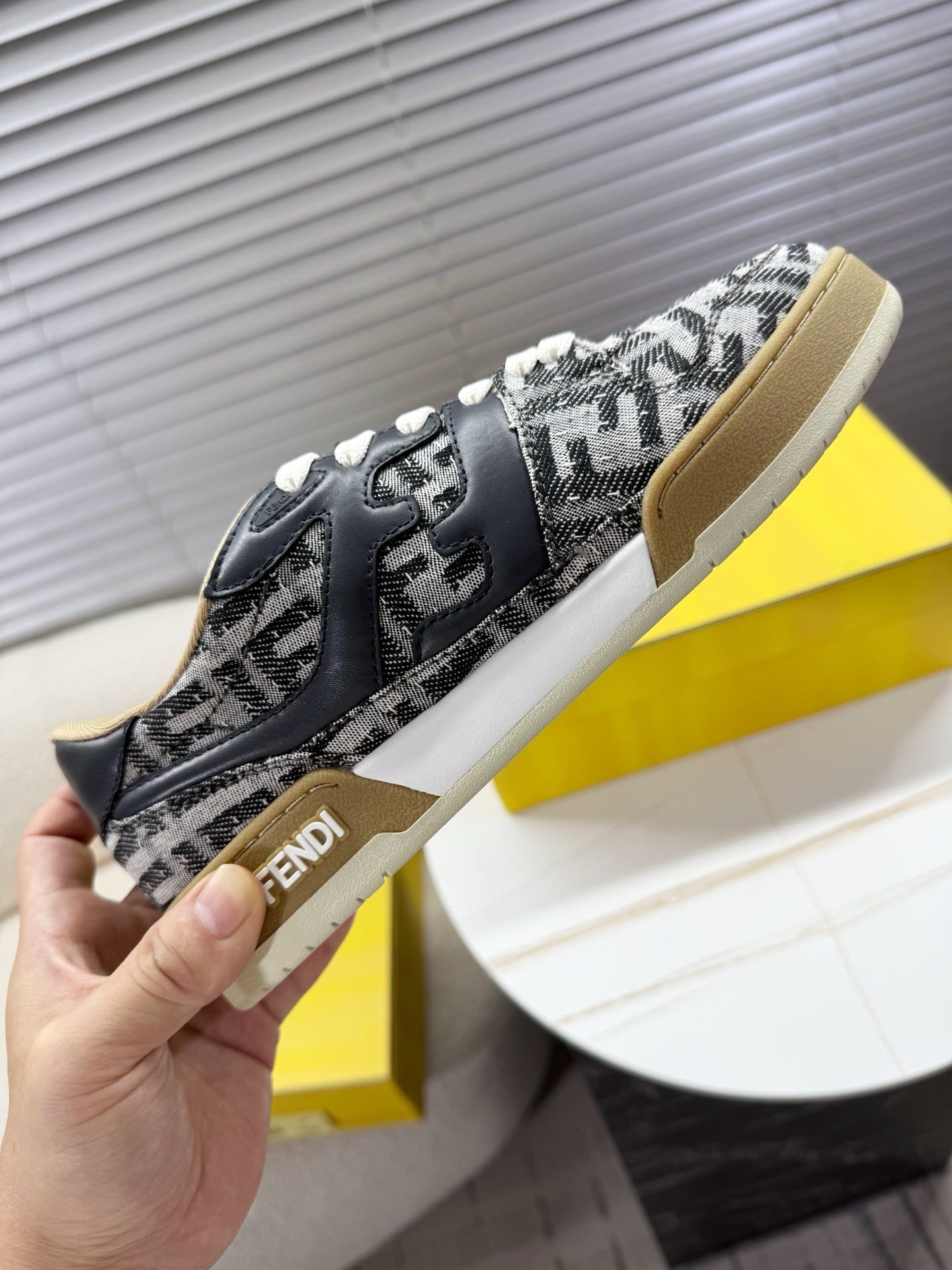 Fendi unisex sneakers held up, black and white FF pattern, chunky white sole