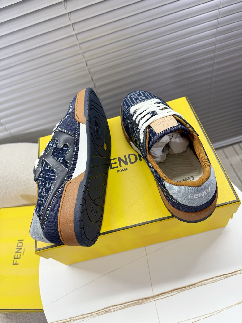 Navy Fendi sneakers with FF logo sides, open heel collar, white laces, tan rubber sole.