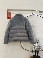 Dark gray hooded puffer jacket with horizontal quilting, back view on a hanger