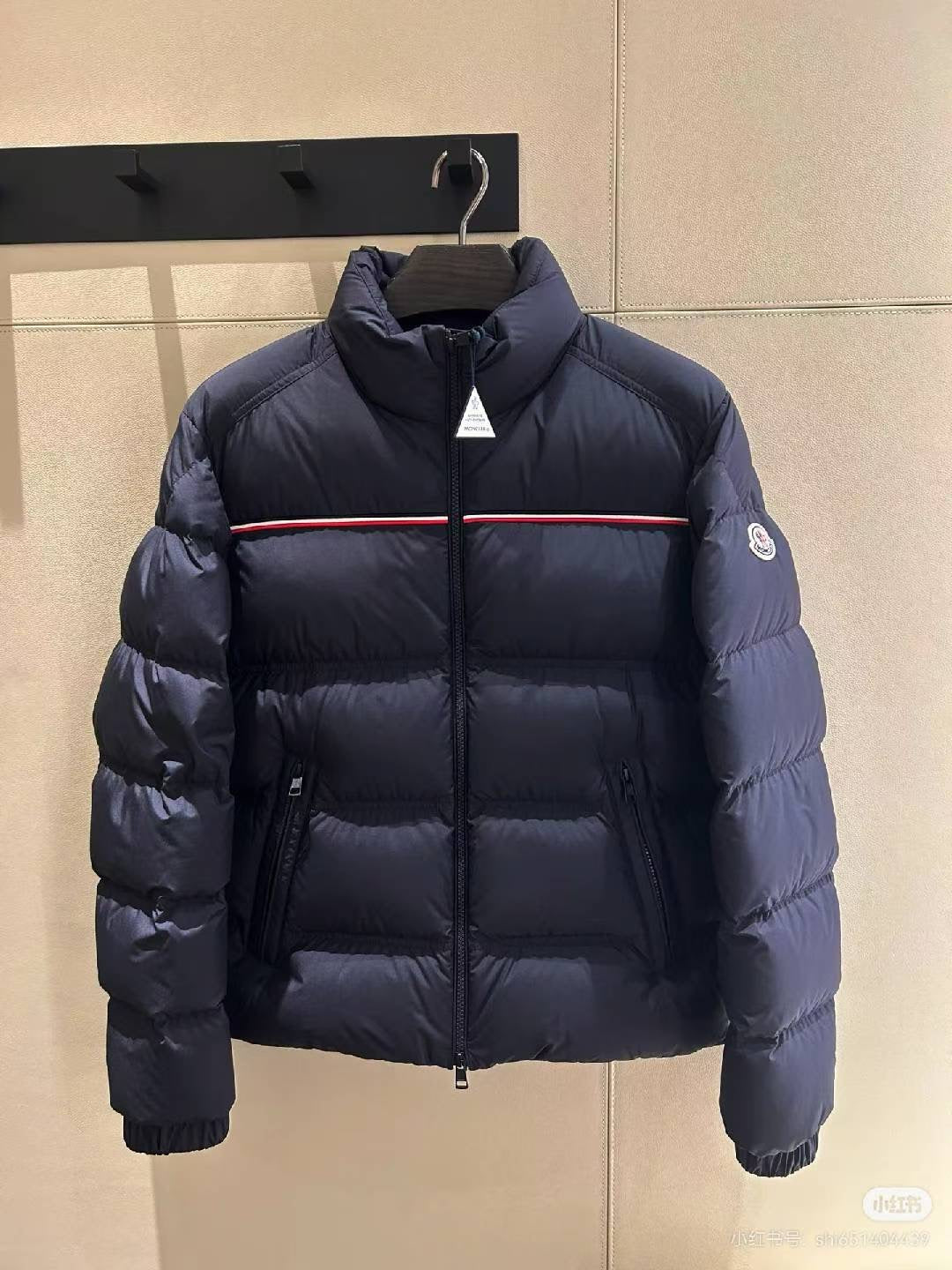 Navy puffer jacket, front zipper, red stripe across chest, stand collar