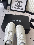 White leather lace-up sneakers with Chanel logo on tongue and front