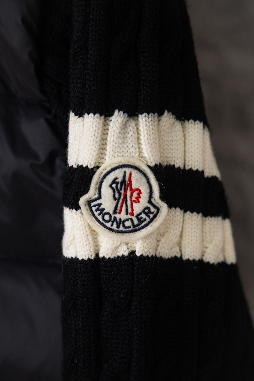 Moncler logo patch on knit cuff, black and white striped ribbed trim