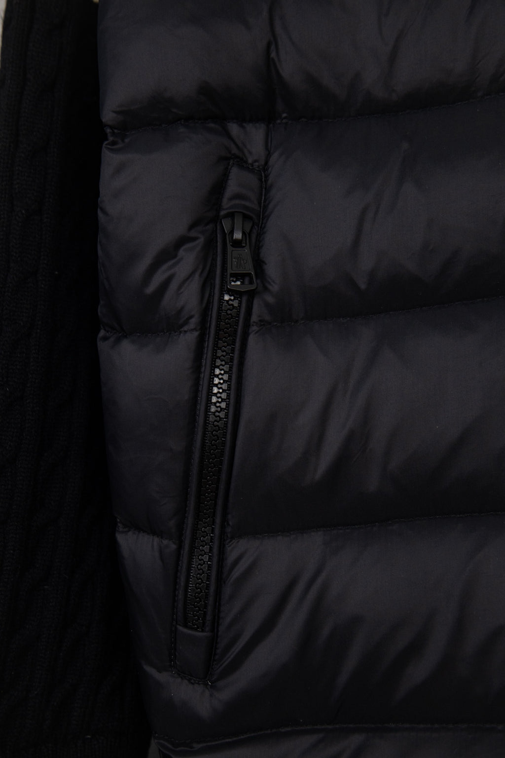 Moncler puffer jacket torso close-up, black quilted panels and zipper
