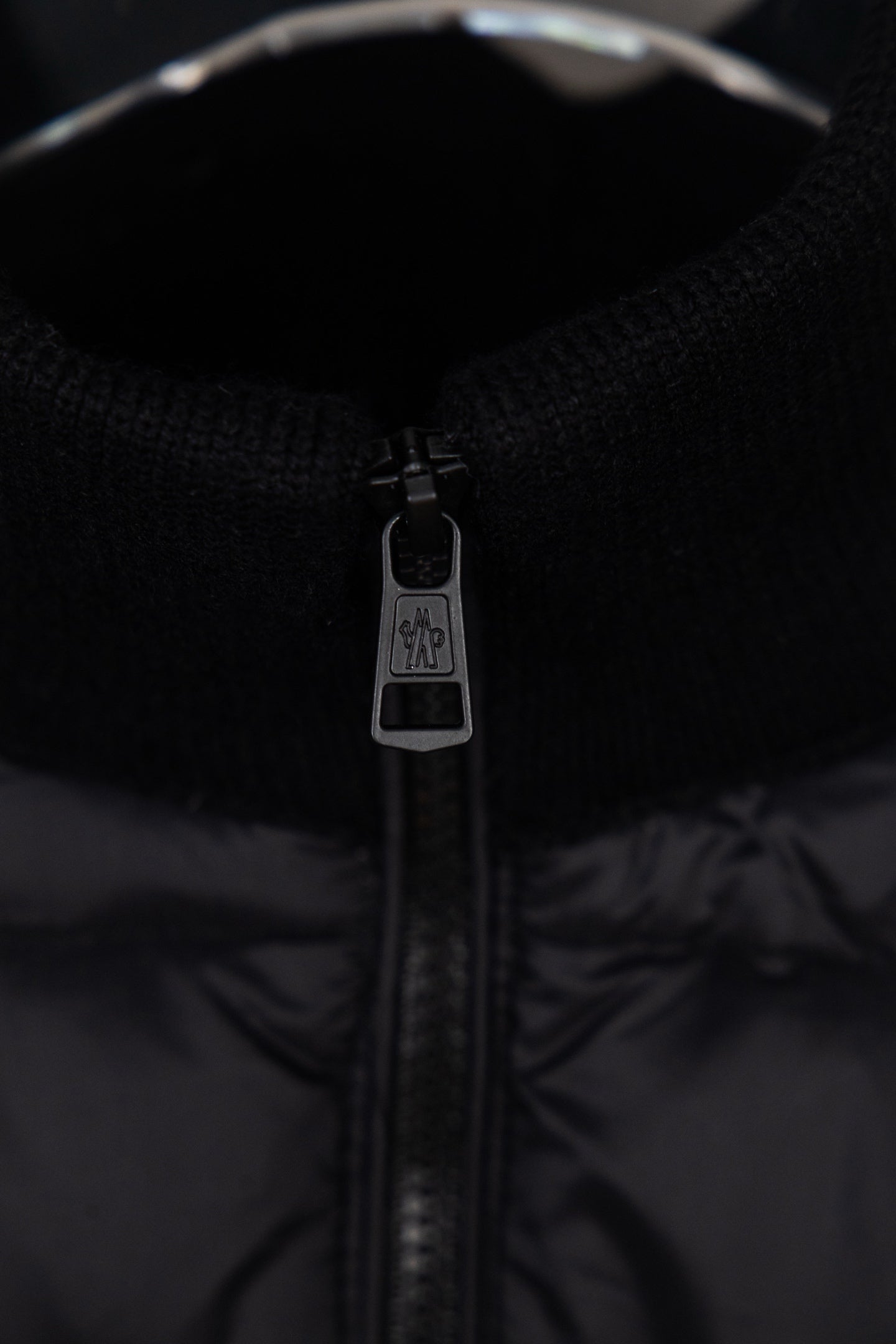 Moncler puffer jacket zip close-up with branded pull tab