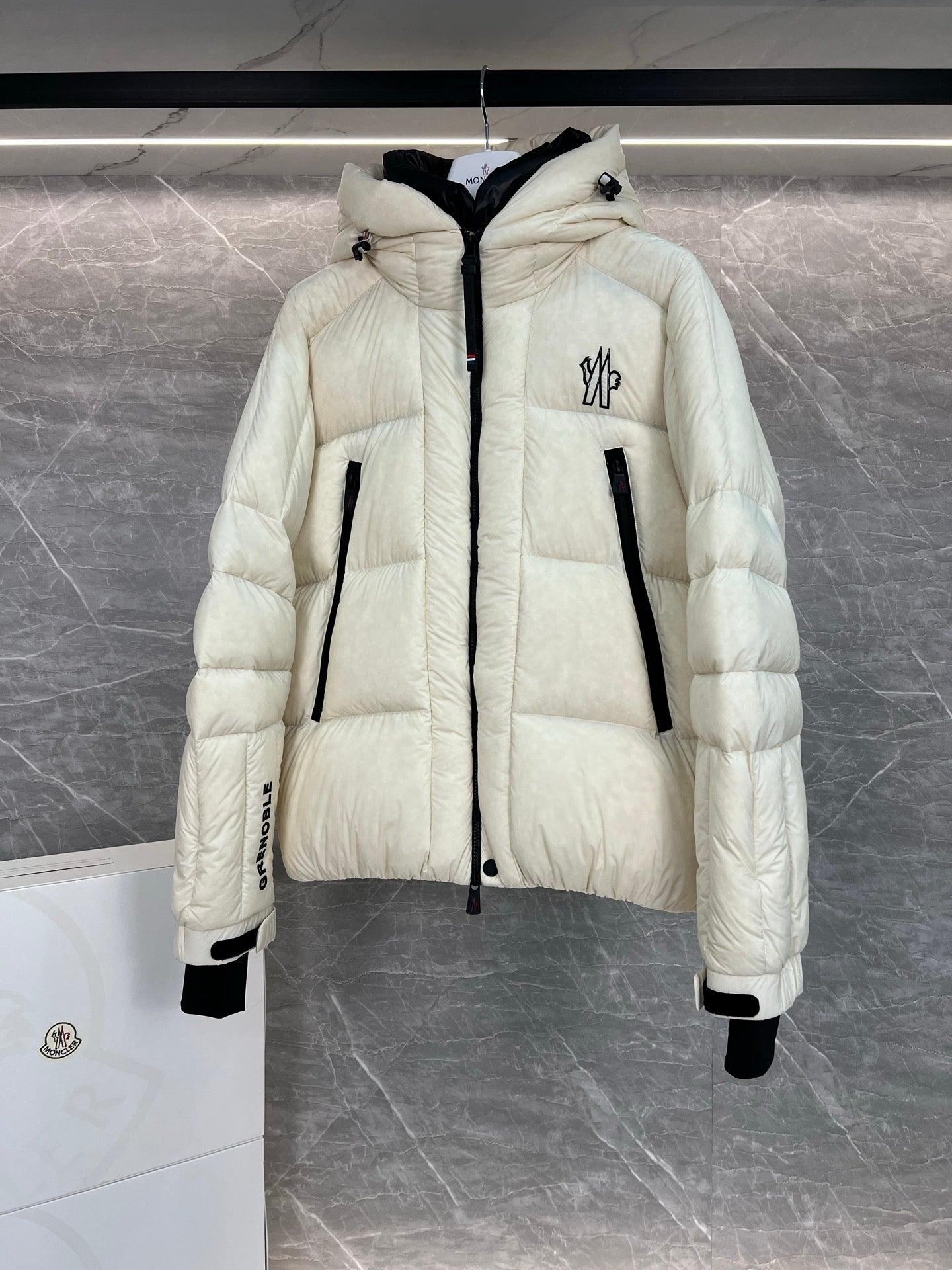 Cream long puffer jacket with hood, front zip closure, quilted texture, flap pockets