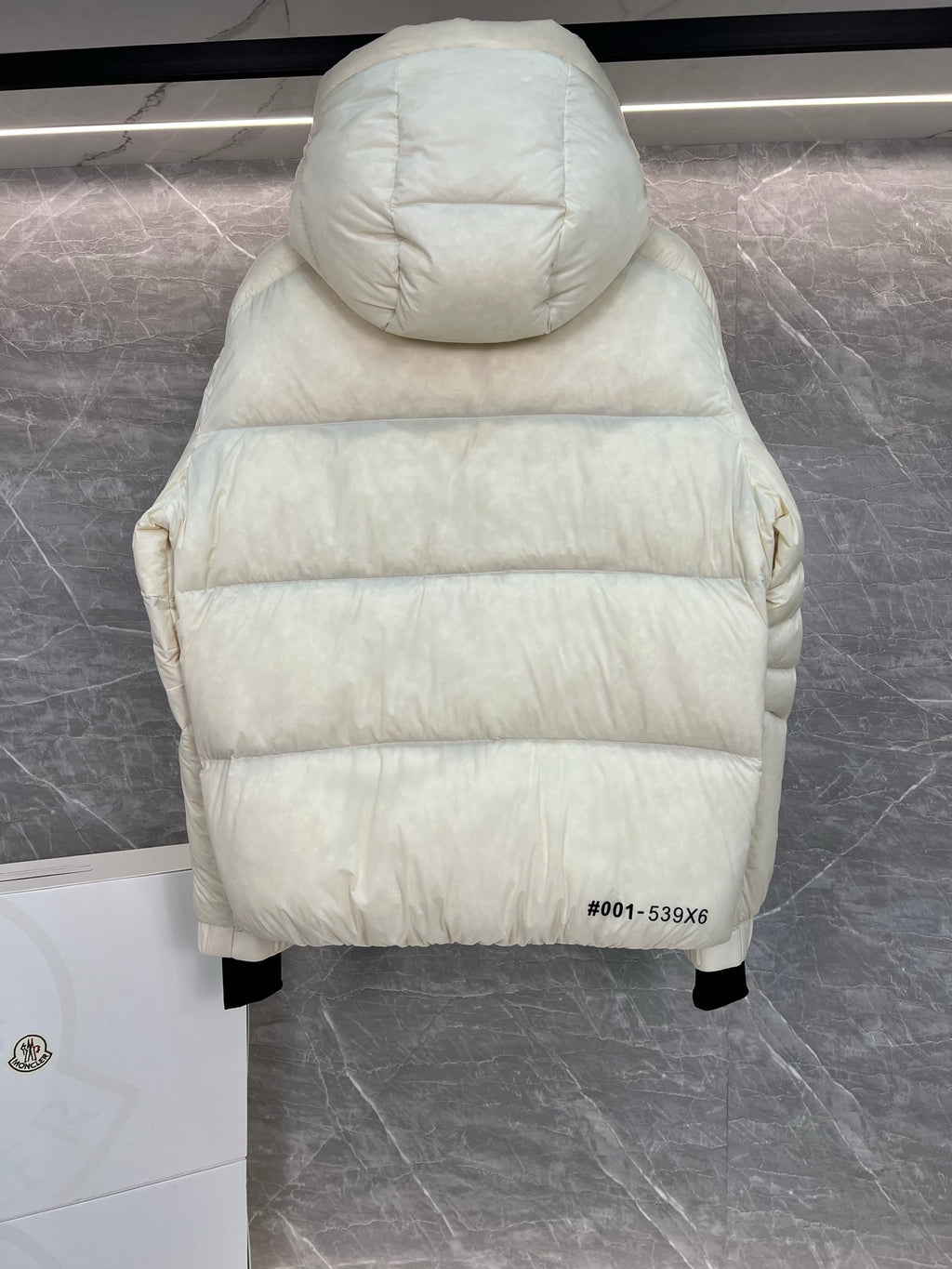 Cream long puffer jacket back view with hood, quilted construction, straight hem