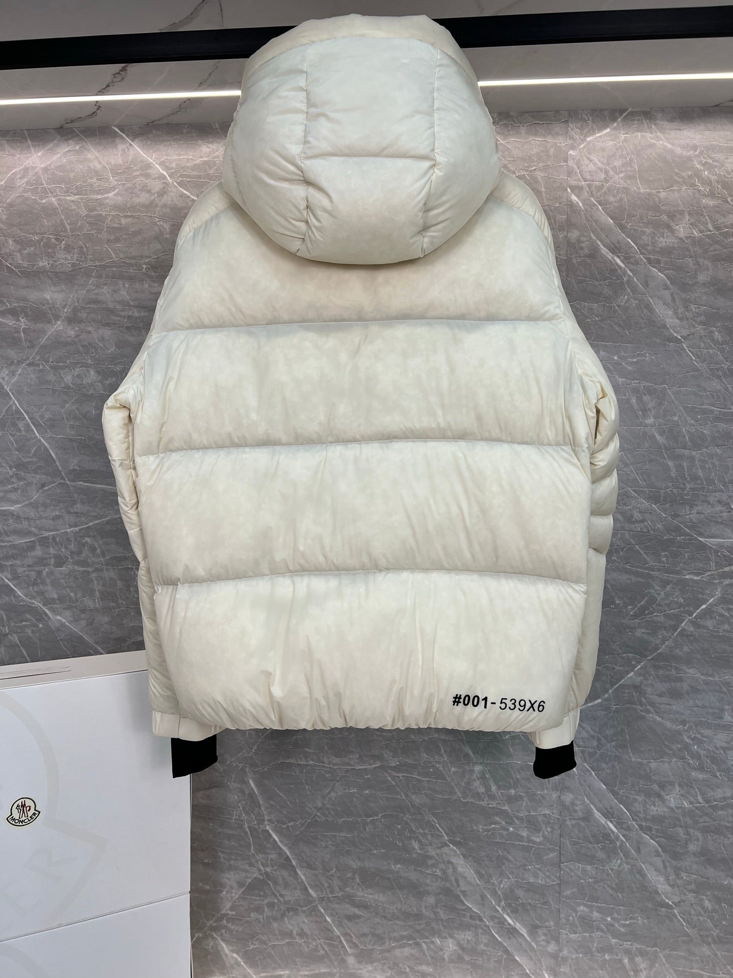 Cream long puffer jacket back view with hood, quilted construction, straight hem