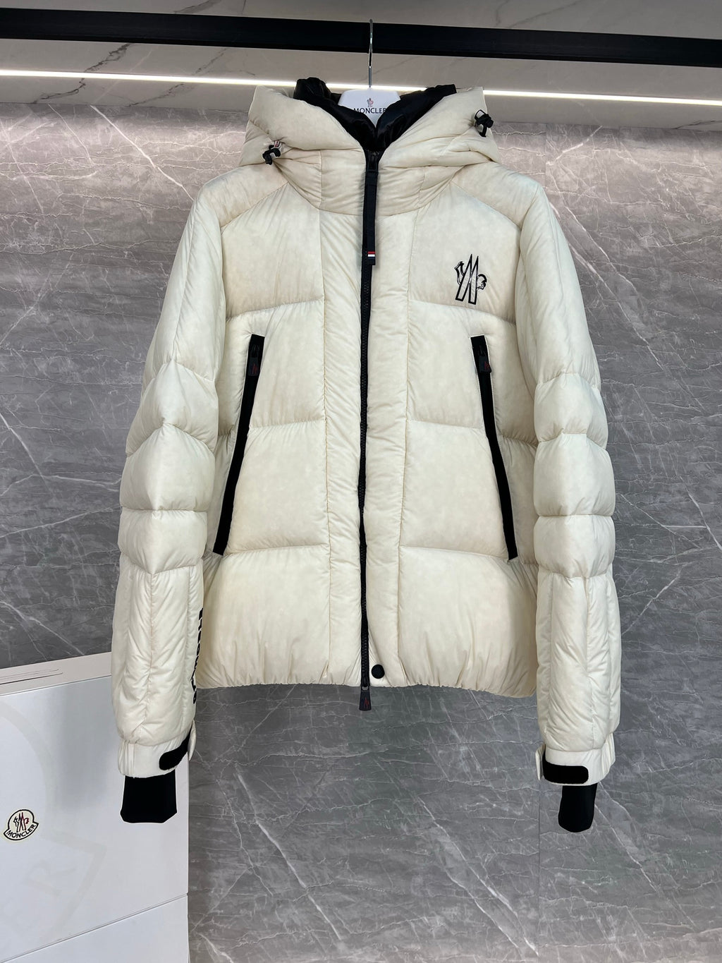 Cream long puffer jacket with hood, front zip, quilted panels, black-trim pockets