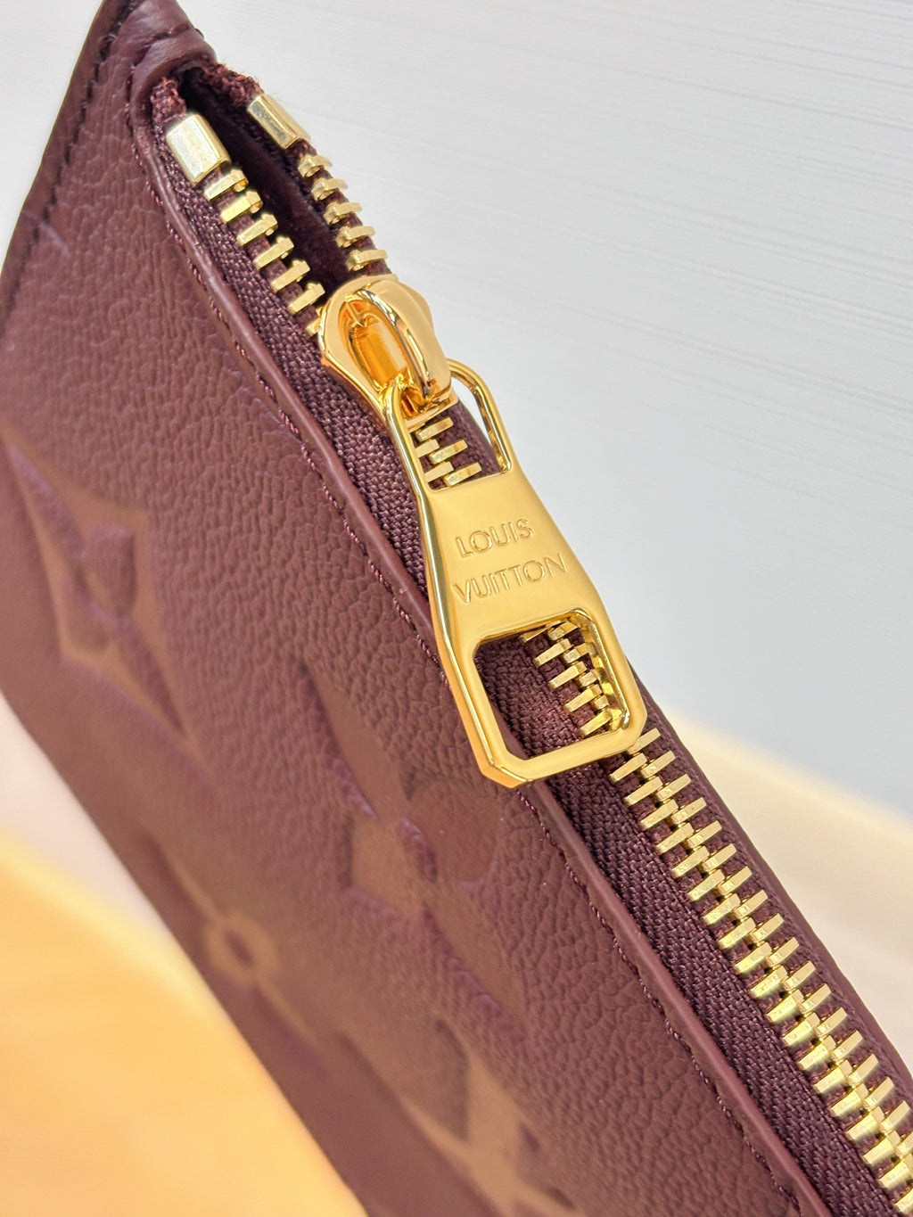 Louis Vuitton monogram bag zipper detail in dark plum with gold-tone zipper pull